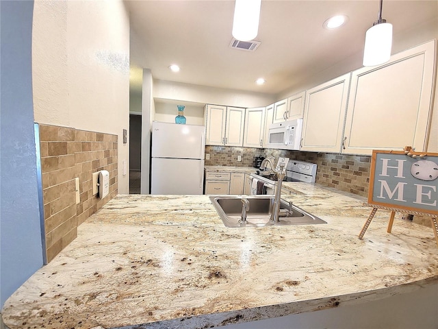 1108 Northlake Dr Unit 1108, Sanford, FL 32773 - kitchen featuring white appliances, a peninsula, a sink, light stone counters, and decorative backsplash