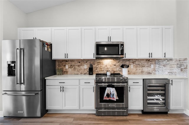 5478 NW 153rd Ct, Morriston, FL 32668 - kitchen featuring appliances with stainless steel finishes, wine cooler, light countertops, white cabinetry, and backsplash