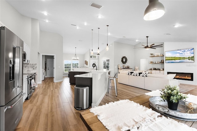 5478 NW 153rd Ct, Morriston, FL 32668 - kitchen with stainless steel appliances, high vaulted ceiling, a glass covered fireplace, a ceiling fan, and open floor plan
