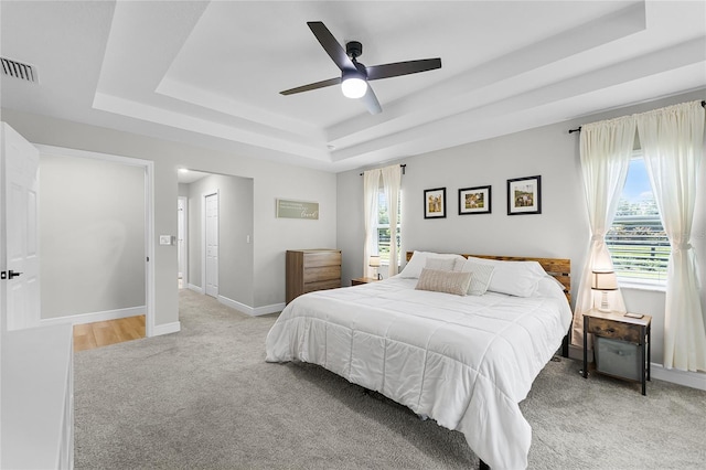 5478 NW 153rd Ct, Morriston, FL 32668 - bedroom with a raised ceiling, light colored carpet, multiple windows, and baseboards