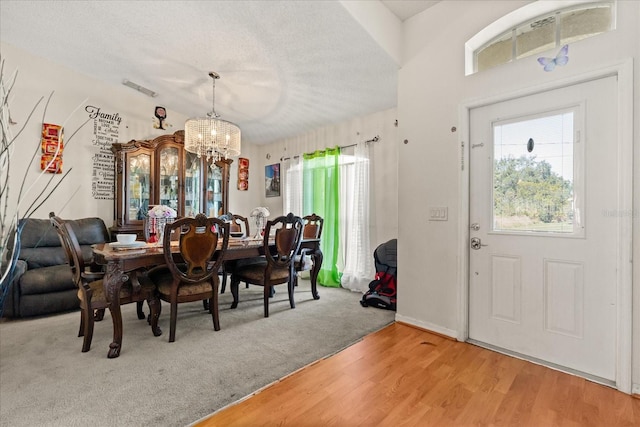 1321 Dunbarton Ct, Kissimmee, FL 34758 - dining room with a chandelier, a textured ceiling, and light wood-style flooring