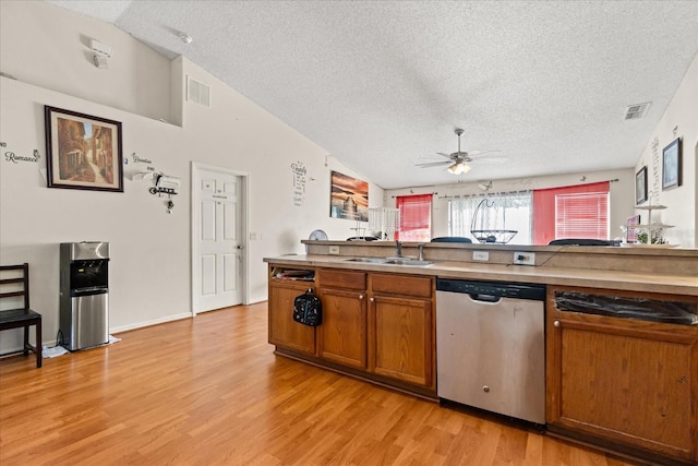 1321 Dunbarton Ct, Kissimmee, FL 34758 - kitchen featuring stainless steel dishwasher, a textured ceiling, a sink, brown cabinets, and lofted ceiling