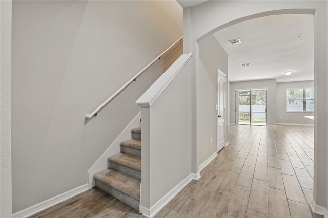 328 Cedar Bark Ln, Sanford, FL 32771 - stairway featuring wood finished floors, arched walkways, and baseboards