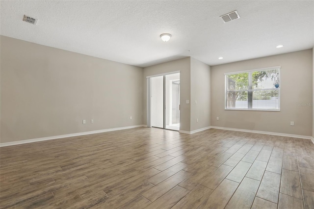 328 Cedar Bark Ln, Sanford, FL 32771 - spare room featuring wood finished floors, a textured ceiling, baseboards, and recessed lighting