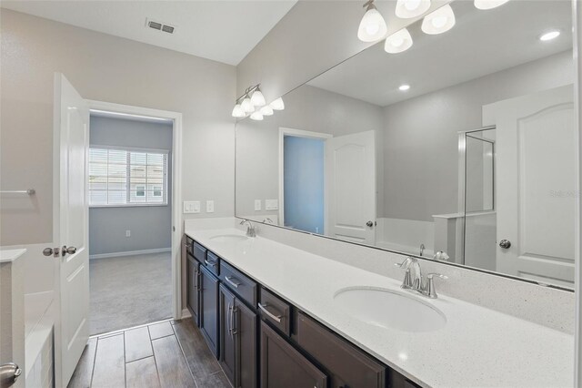 328 Cedar Bark Ln, Sanford, FL 32771 - bathroom with double vanity, wood finished floors, a shower, and baseboards