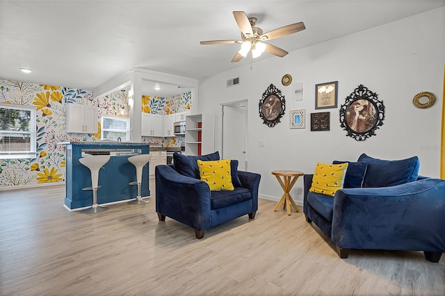 826 Cherokee Cir, Sanford, FL 32773 - living room with wallpapered walls, light wood-style flooring, baseboards, and a ceiling fan