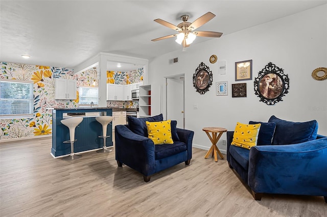 826 Cherokee Cir, Sanford, FL 32773 - living room featuring wallpapered walls, light wood-type flooring, baseboards, and a ceiling fan