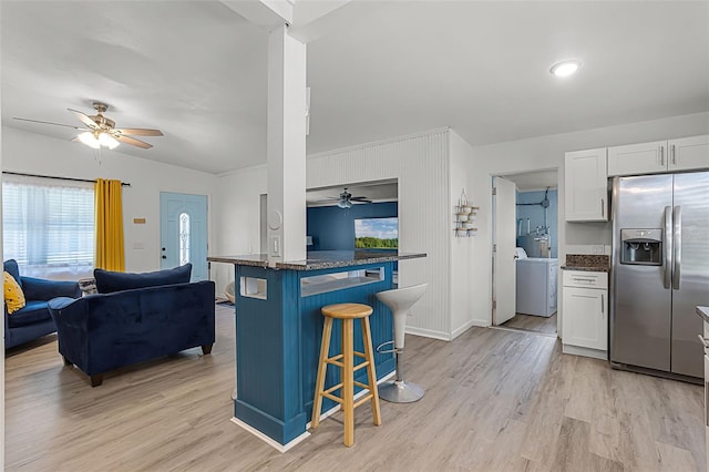 826 Cherokee Cir, Sanford, FL 32773 - kitchen with stainless steel refrigerator with ice dispenser, a ceiling fan, a kitchen bar, and light wood finished floors