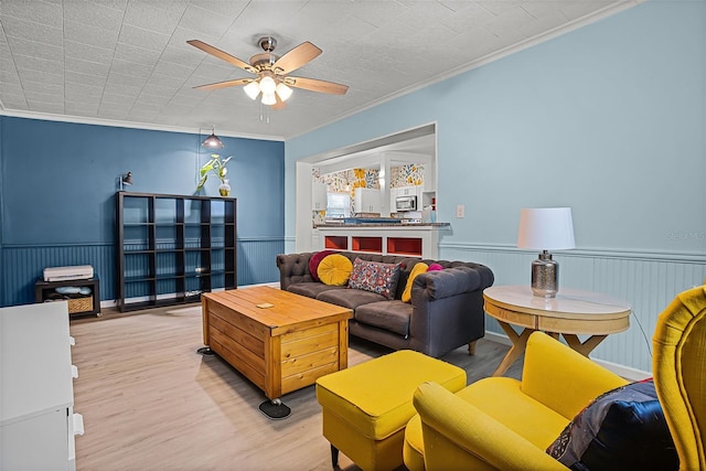 826 Cherokee Cir, Sanford, FL 32773 - living room with a ceiling fan, wood finished floors, crown molding, and a wainscoted wall