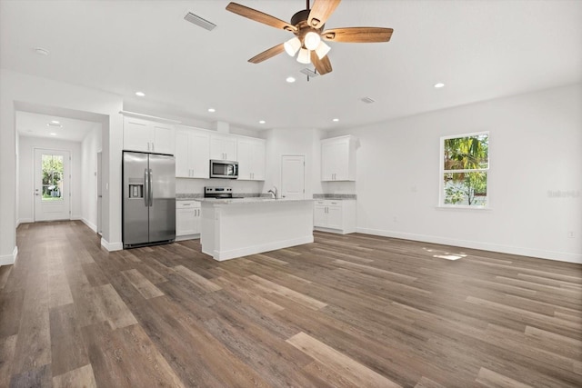 1119 W 7th St, Sanford, FL 32771 - kitchen with appliances with stainless steel finishes, wood finished floors, recessed lighting, light countertops, and an island with sink
