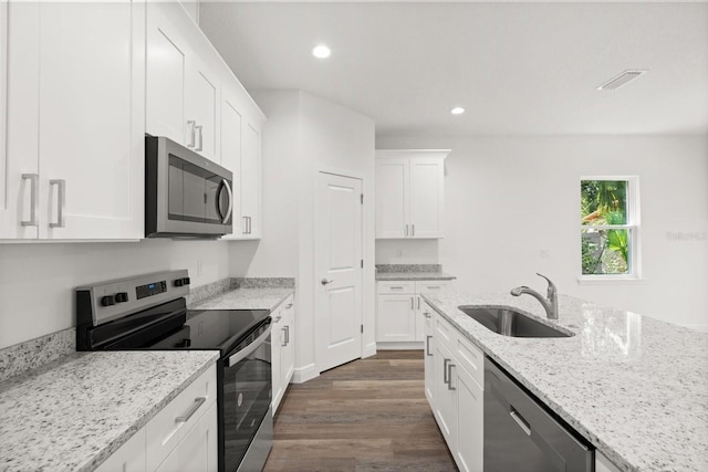 1119 W 7th St, Sanford, FL 32771 - kitchen with stainless steel appliances, a sink, dark wood-style floors, white cabinetry, and recessed lighting