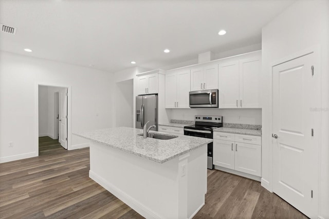 1119 W 7th St, Sanford, FL 32771 - kitchen featuring stainless steel appliances, a sink, white cabinets, dark wood finished floors, and an island with sink