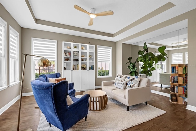 16086 Johns Lake Overlook Dr, Winter Garden, FL 34787 - living area with a tray ceiling, ceiling fan, wood finished floors, and baseboards