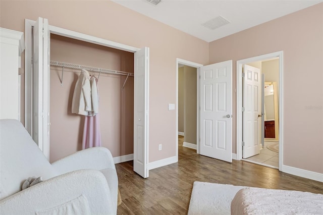 16086 Johns Lake Overlook Dr, Winter Garden, FL 34787 - bedroom featuring wood finished floors, a closet, baseboards, and connected bathroom