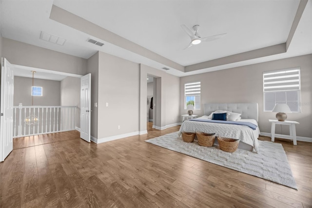 16086 Johns Lake Overlook Dr, Winter Garden, FL 34787 - bedroom with wood finished floors, baseboards, a tray ceiling, and ceiling fan