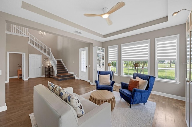 16086 Johns Lake Overlook Dr, Winter Garden, FL 34787 - living area featuring a tray ceiling, baseboards, wood finished floors, and stairway