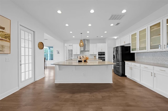 16086 Johns Lake Overlook Dr, Winter Garden, FL 34787 - kitchen featuring wall chimney exhaust hood, black refrigerator with ice dispenser, white cabinets, a center island with sink, and recessed lighting