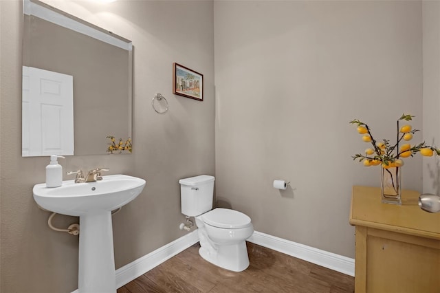 16086 Johns Lake Overlook Dr, Winter Garden, FL 34787 - bathroom with toilet, baseboards, wood finished floors, and a sink