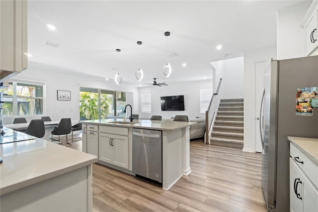 2227 Blue Salvia St, Clermont, FL 34711 - kitchen with appliances with stainless steel finishes, a sink, light countertops, light wood-type flooring, and open floor plan