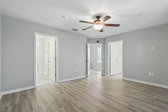 10172 Storey Grove Way, Winter Garden, FL 34787 - unfurnished bedroom featuring wood finished floors, baseboards, ensuite bath, and ceiling fan