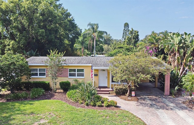2810 Nancy St, Orlando, FL 32806 - view of front of home with decorative driveway, a front yard, and a shingled roof