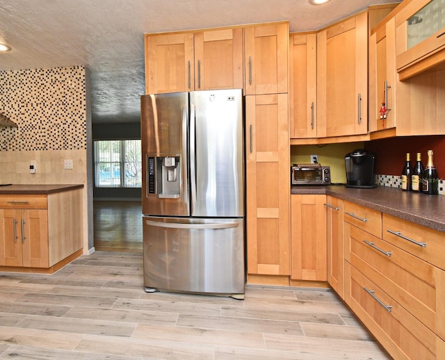2810 Nancy St, Orlando, FL 32806 - kitchen with stainless steel fridge with ice dispenser, dark countertops, light wood-style floors, recessed lighting, and glass insert cabinets