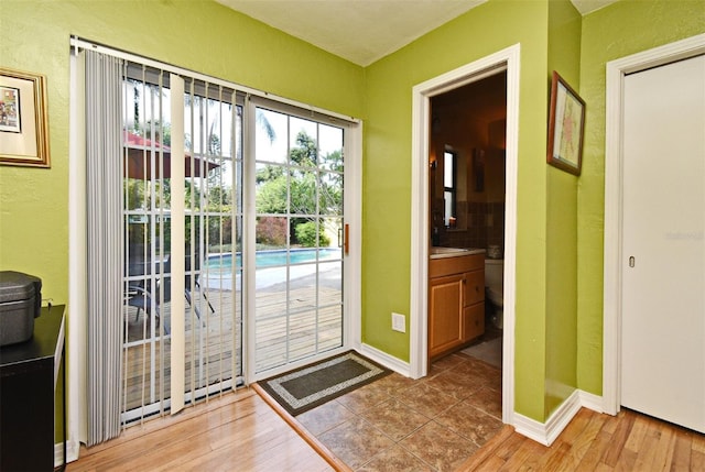 2810 Nancy St, Orlando, FL 32806 - doorway featuring wood finished floors, baseboards, and a textured wall