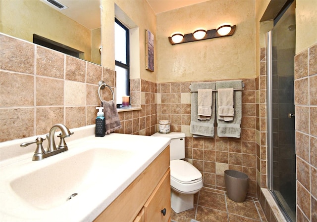 2810 Nancy St, Orlando, FL 32806 - bathroom featuring toilet, tile walls, a shower stall, vanity, and tile patterned flooring