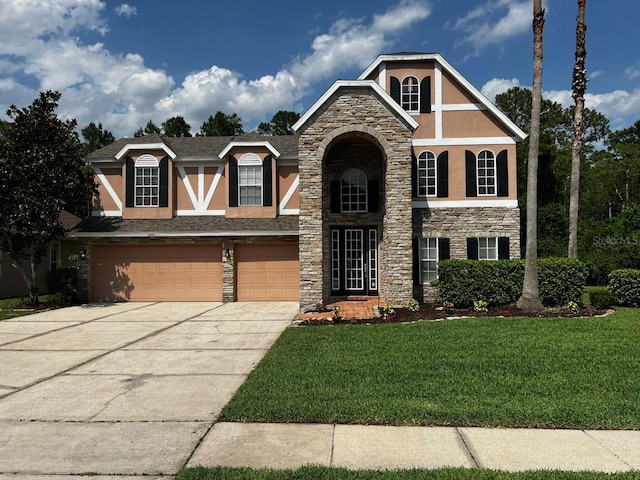 2143 Autumn View Dr, Orlando, FL 32825 - tudor home featuring stucco siding, stone siding, a front yard, an attached garage, and concrete driveway