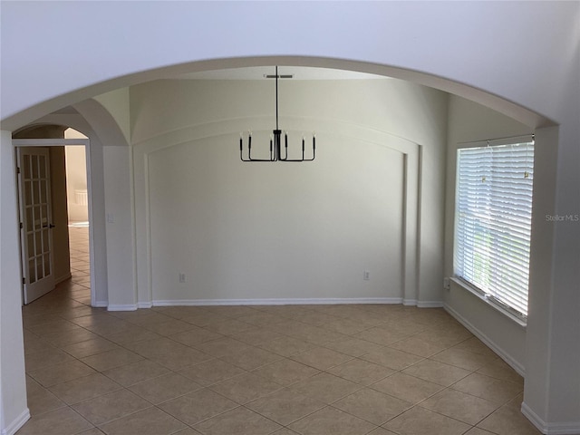 2143 Autumn View Dr, Orlando, FL 32825 - unfurnished dining area featuring light tile patterned floors, a chandelier, arched walkways, and baseboards