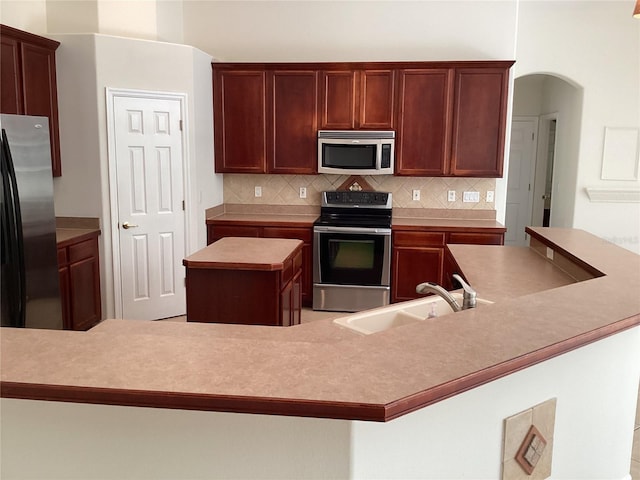 2143 Autumn View Dr, Orlando, FL 32825 - kitchen with stainless steel appliances, a sink, a center island, tasteful backsplash, and light countertops