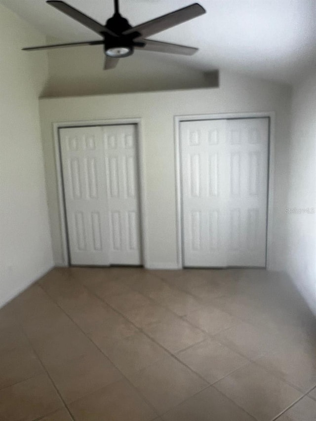 2143 Autumn View Dr, Orlando, FL 32825 - unfurnished bedroom with tile patterned flooring, lofted ceiling, ceiling fan, and multiple closets