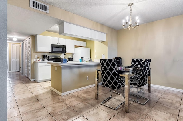 8719 Rockingham Ter Unit B, Kissimmee, FL 34747 - kitchen with black microwave, stainless steel electric range, freestanding refrigerator, a textured ceiling, and a chandelier