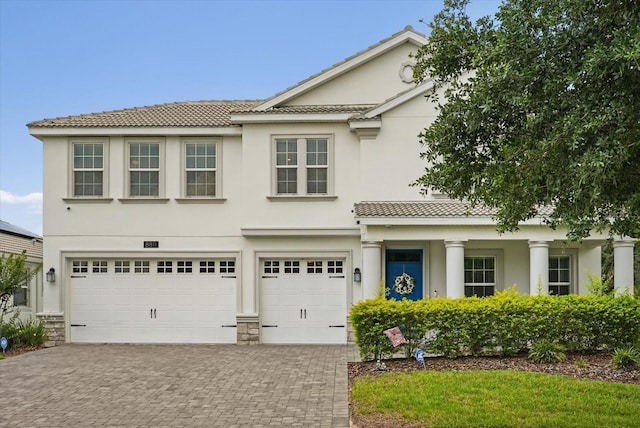 8811 Bally Neal Loop, Davenport, FL 33896 - view of front of house with decorative driveway, an attached garage, stucco siding, and a tile roof