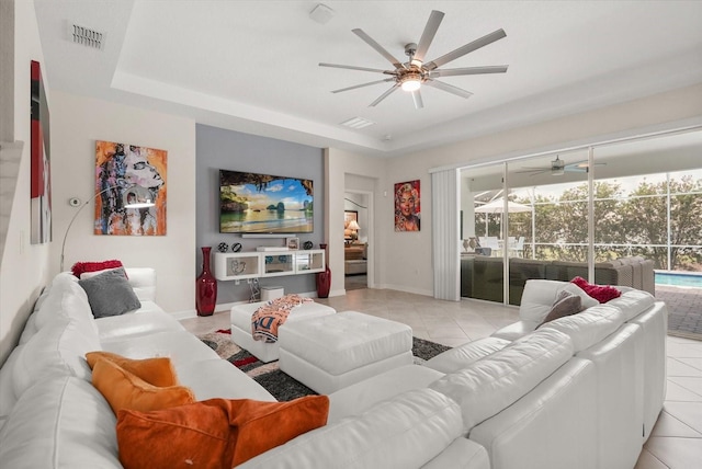 8811 Bally Neal Loop, Davenport, FL 33896 - living room featuring ceiling fan, light tile patterned flooring, baseboards, and a raised ceiling