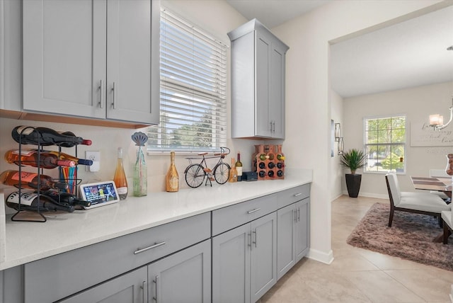 8811 Bally Neal Loop, Davenport, FL 33896 - kitchen featuring gray cabinetry, light countertops, light tile patterned floors, and baseboards