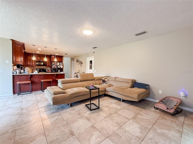 6047 Shore Line Dr, Orlando, FL 32819 - living area with a textured ceiling, baseboards, and light tile patterned floors