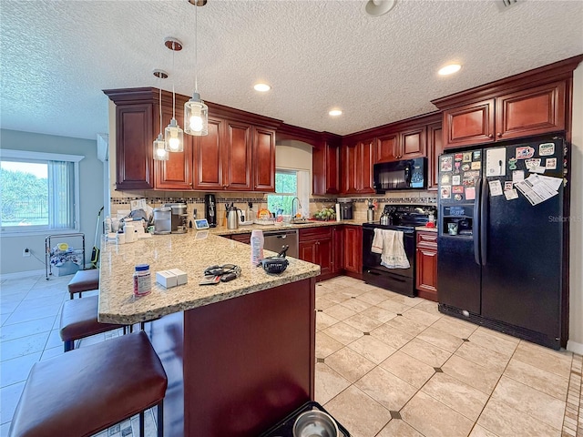 6047 Shore Line Dr, Orlando, FL 32819 - kitchen with black appliances, a peninsula, a sink, a breakfast bar, and backsplash