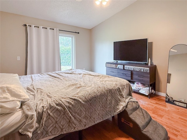 6047 Shore Line Dr, Orlando, FL 32819 - bedroom featuring wood finished floors, vaulted ceiling, a textured ceiling, and baseboards