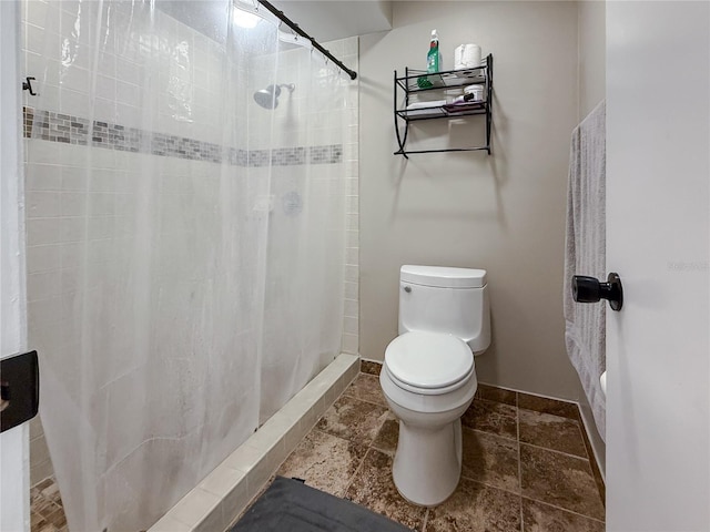 6047 Shore Line Dr, Orlando, FL 32819 - full bathroom featuring toilet, a tile shower, and baseboards