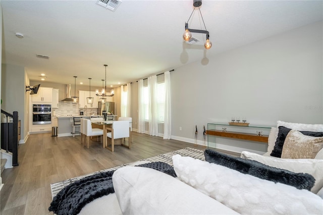 12259 Bracco St, Winter Garden, FL 34787 - living area featuring light wood-style floors, baseboards, a chandelier, and recessed lighting