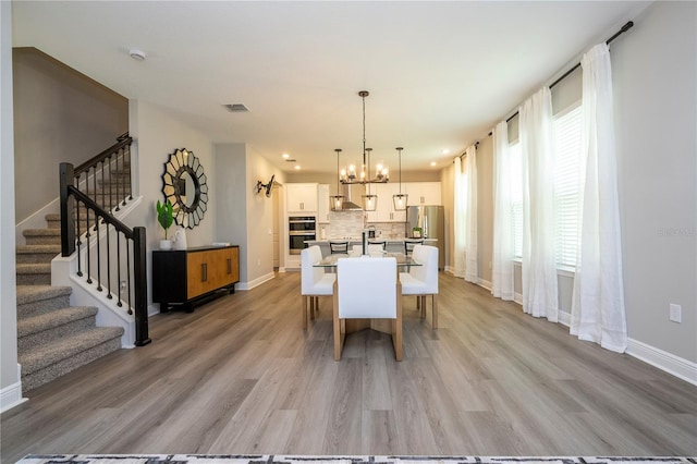 12259 Bracco St, Winter Garden, FL 34787 - dining area featuring stairs, a chandelier, light wood finished floors, and baseboards