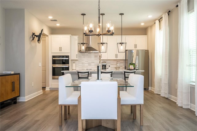 12259 Bracco St, Winter Garden, FL 34787 - dining room with light wood-type flooring, baseboards, a chandelier, and recessed lighting