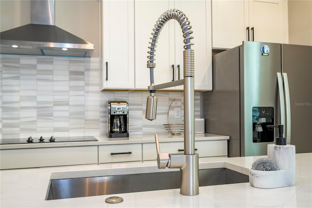 12259 Bracco St, Winter Garden, FL 34787 - kitchen with wall chimney range hood, stainless steel fridge, tasteful backsplash, white cabinets, and black electric cooktop