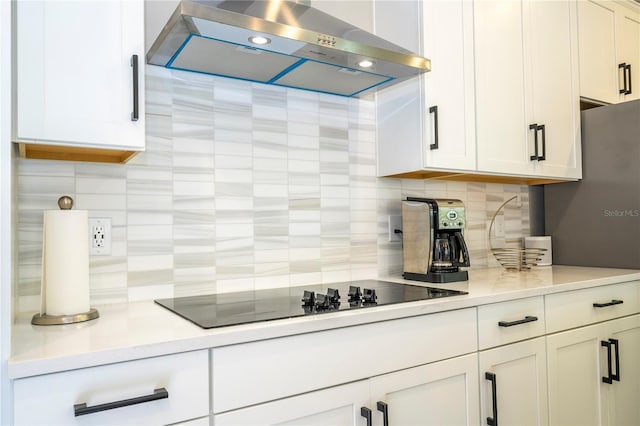 12259 Bracco St, Winter Garden, FL 34787 - kitchen with ventilation hood, decorative backsplash, black electric stovetop, white cabinets, and light countertops
