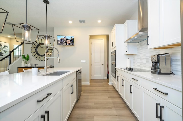 12259 Bracco St, Winter Garden, FL 34787 - kitchen with wall chimney range hood, a sink, appliances with stainless steel finishes, white cabinetry, and decorative backsplash