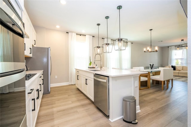 12259 Bracco St, Winter Garden, FL 34787 - kitchen with a sink, stainless steel appliances, a chandelier, a kitchen island with sink, and white cabinetry