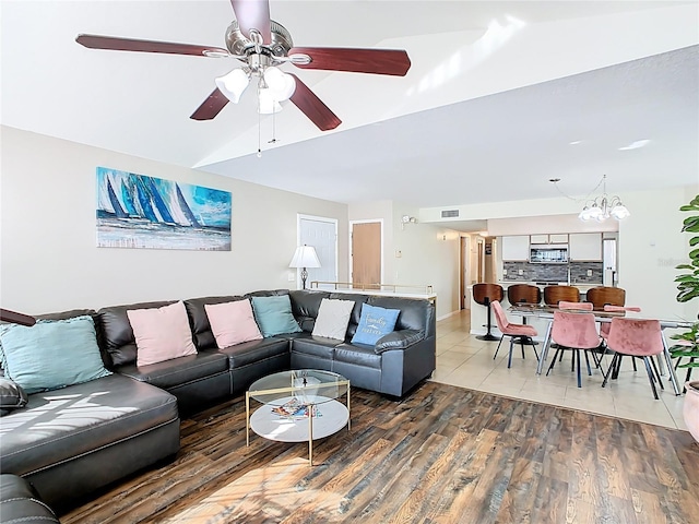 8704 Knightsbridge Ct Unit B, Kissimmee, FL 34747 - living area featuring a ceiling fan, light wood-style floors, lofted ceiling, a chandelier, and baseboards