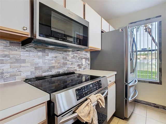 8704 Knightsbridge Ct Unit B, Kissimmee, FL 34747 - kitchen featuring appliances with stainless steel finishes, light countertops, white cabinets, and light tile patterned floors