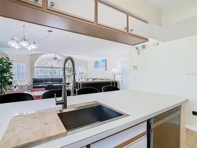 8704 Knightsbridge Ct Unit B, Kissimmee, FL 34747 - kitchen with light countertops, white cabinets, open floor plan, decorative light fixtures, and a chandelier